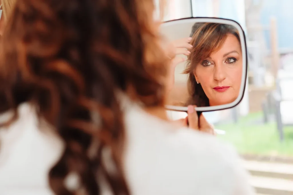 Close-up of Rachel's elegantly styled curls reflected in a mirror during wedding morning preparations before her Georgian Townhouse Norwich wedding