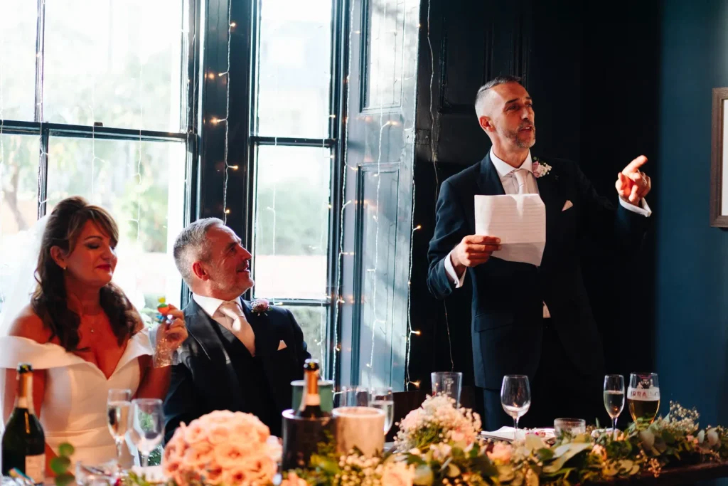 Rachel and Nick seated together at the top table during the wedding speeches at The Georgian Townhouse Norwich reception