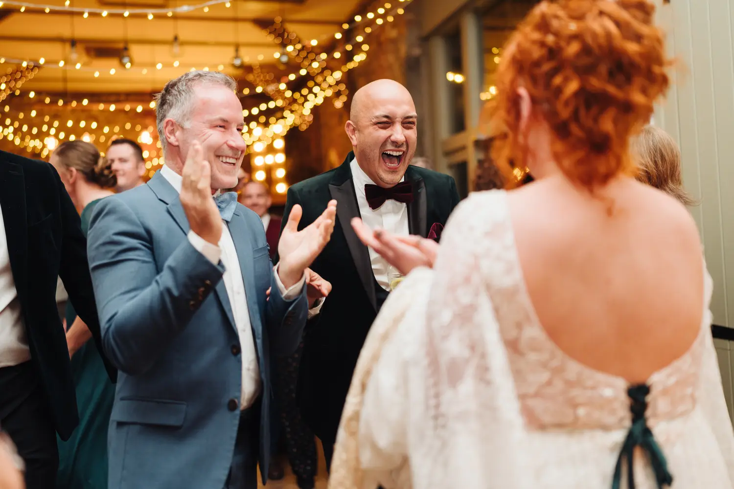 Megan and Sam sharing a joyful dance with family during their evening reception at Pentney Abbey