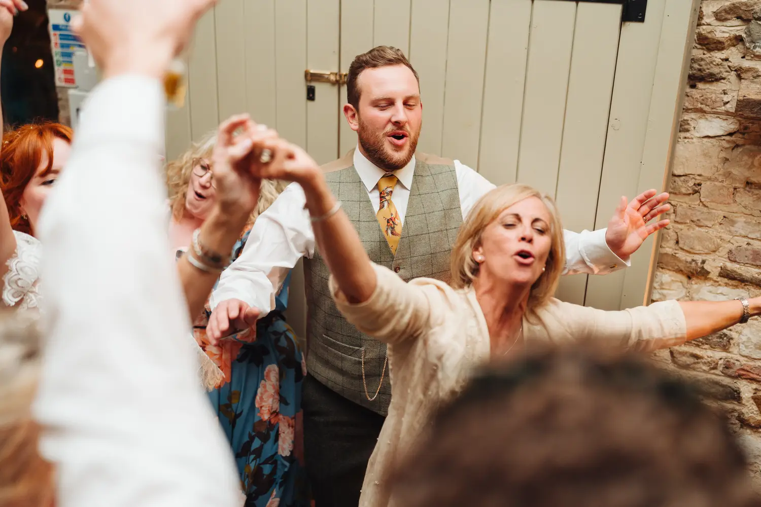 Candid late evening moments of dancing and laughter at the Pentney Abbey wedding reception