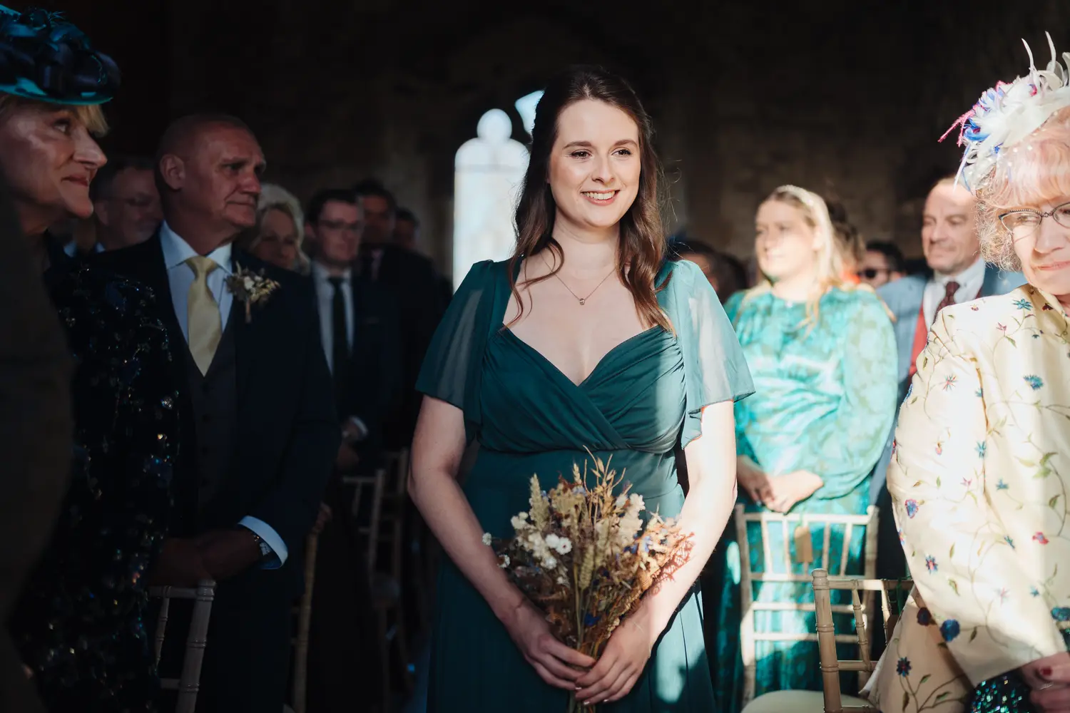 Megan walking down the aisle towards Sam at their Pentney Abbey wedding ceremony in Norfolk