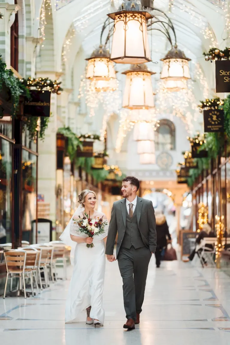 Bride and groom strolling through the festive Royal Arcade in Norwich