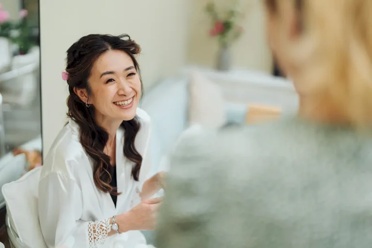 Antonia smiling in her white robe as she chats during wedding morning prep in Suffolk