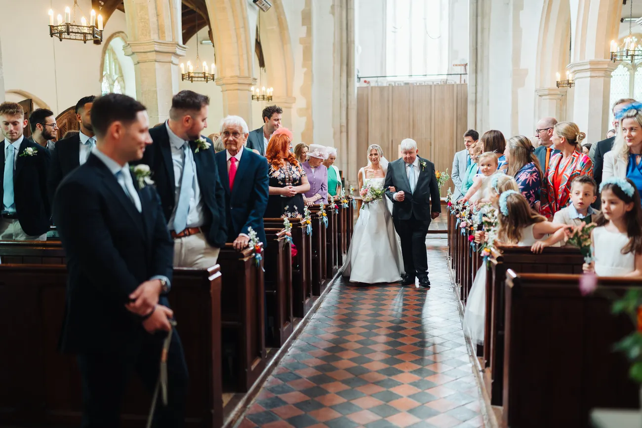 Lucy and George covered in confetti outside St Andrew's Church Eaton Suffolk
