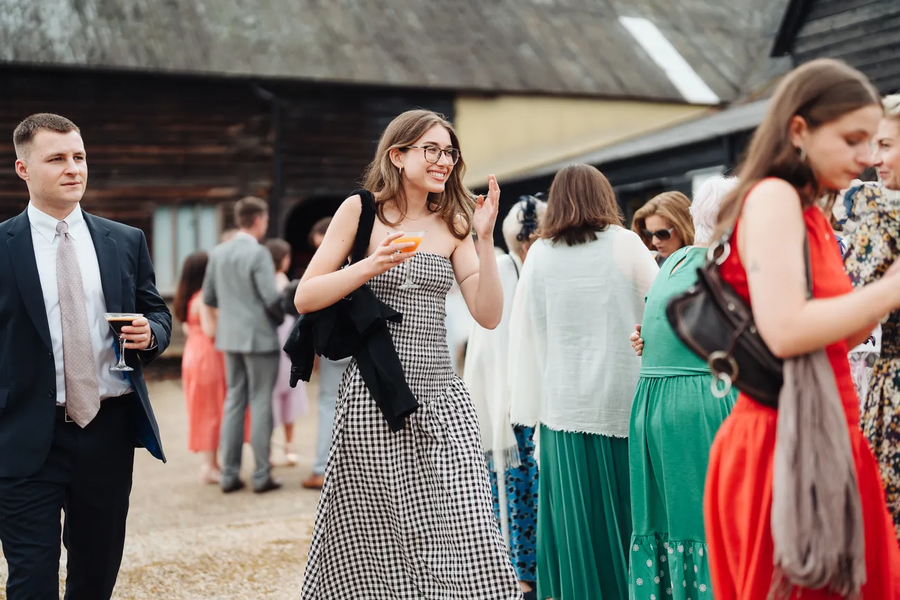Candid laughter at the drinks reception at Preston Priory Barn Suffolk