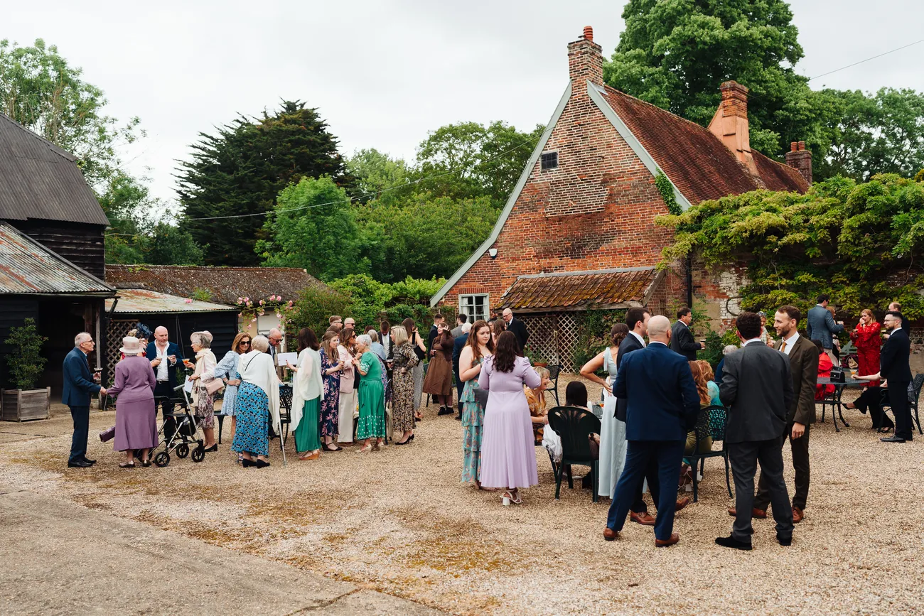 Summer drinks reception in the courtyard at Preston Priory Barn Suffolk wedding