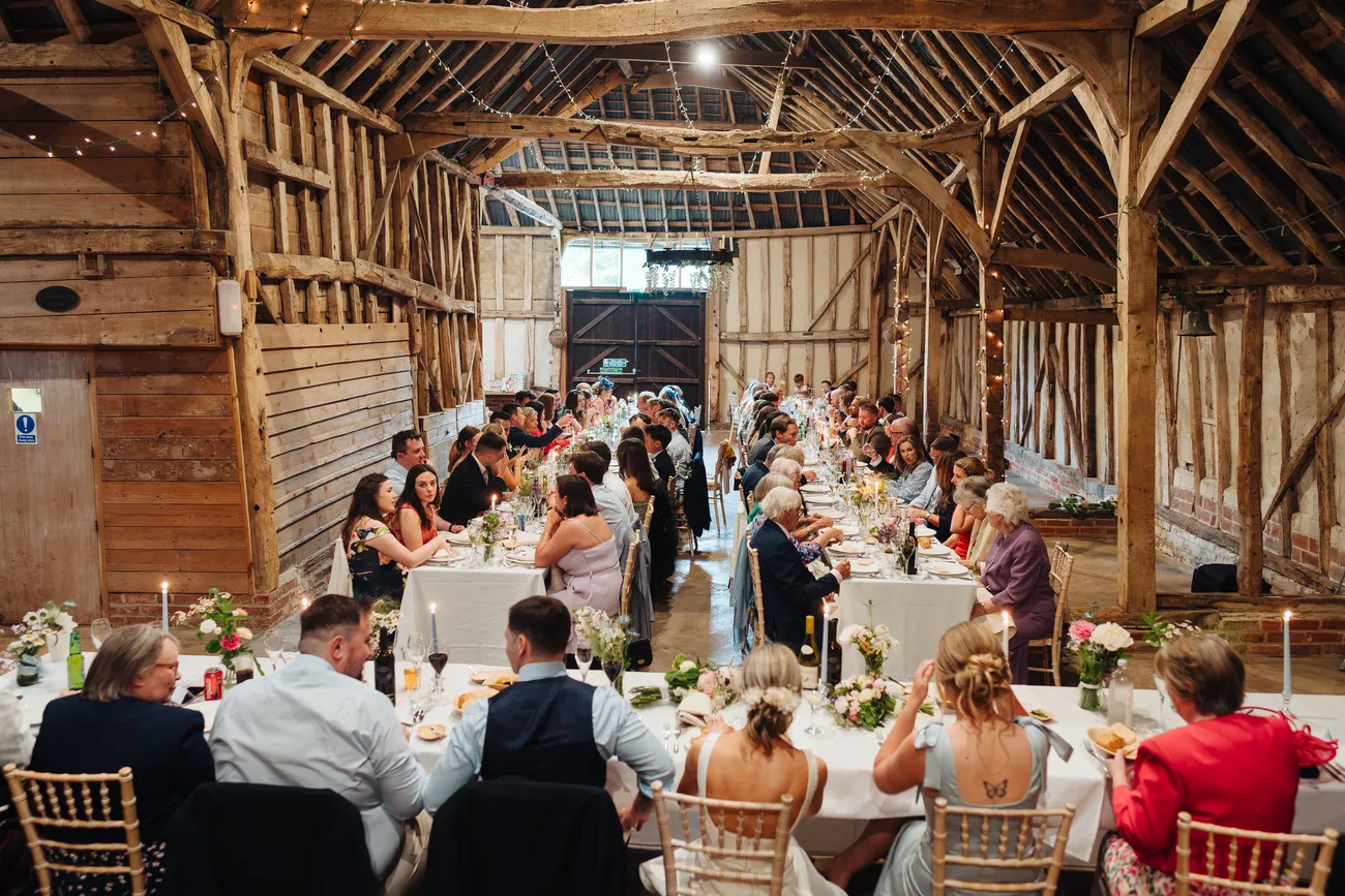 Lucy laughing at the best man's jokes during speeches at Preston Priory Barn