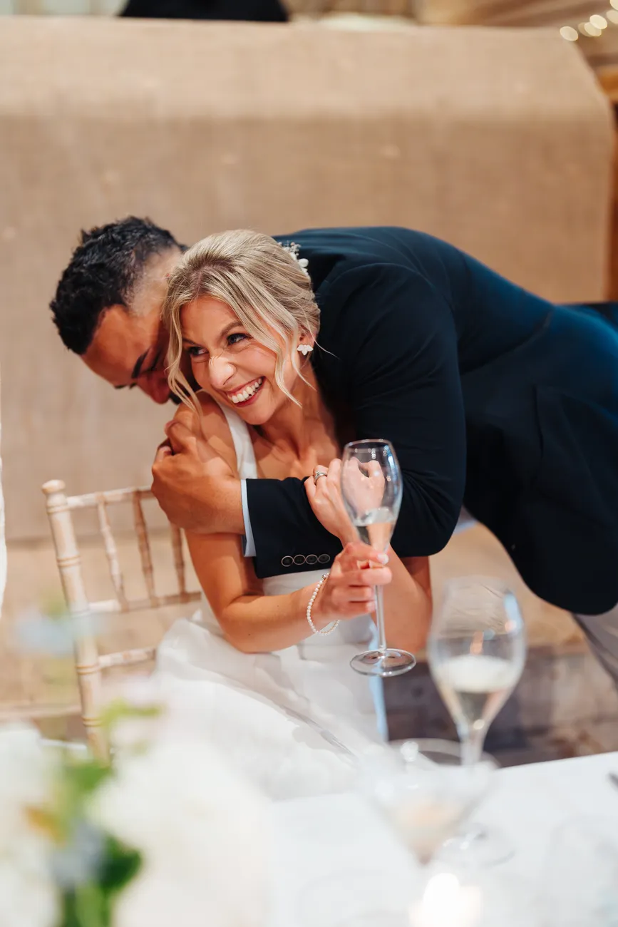 Lucy and George laughing together during their portraits at Preston Priory Barn