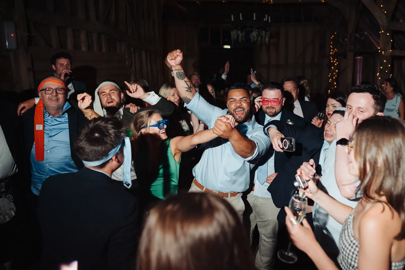 Evening atmosphere inside the medieval barn at Preston Priory Barn Suffolk wedding