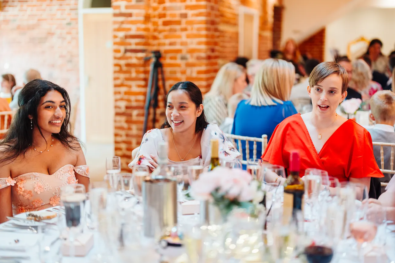 Lewis chatting and laughing with friends at Reymerston Hall wedding